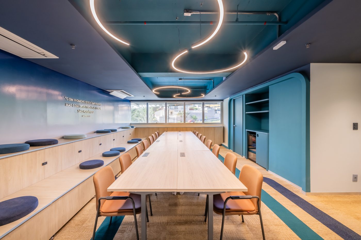 Sala de reuniões com mesa longa e iluminação circular